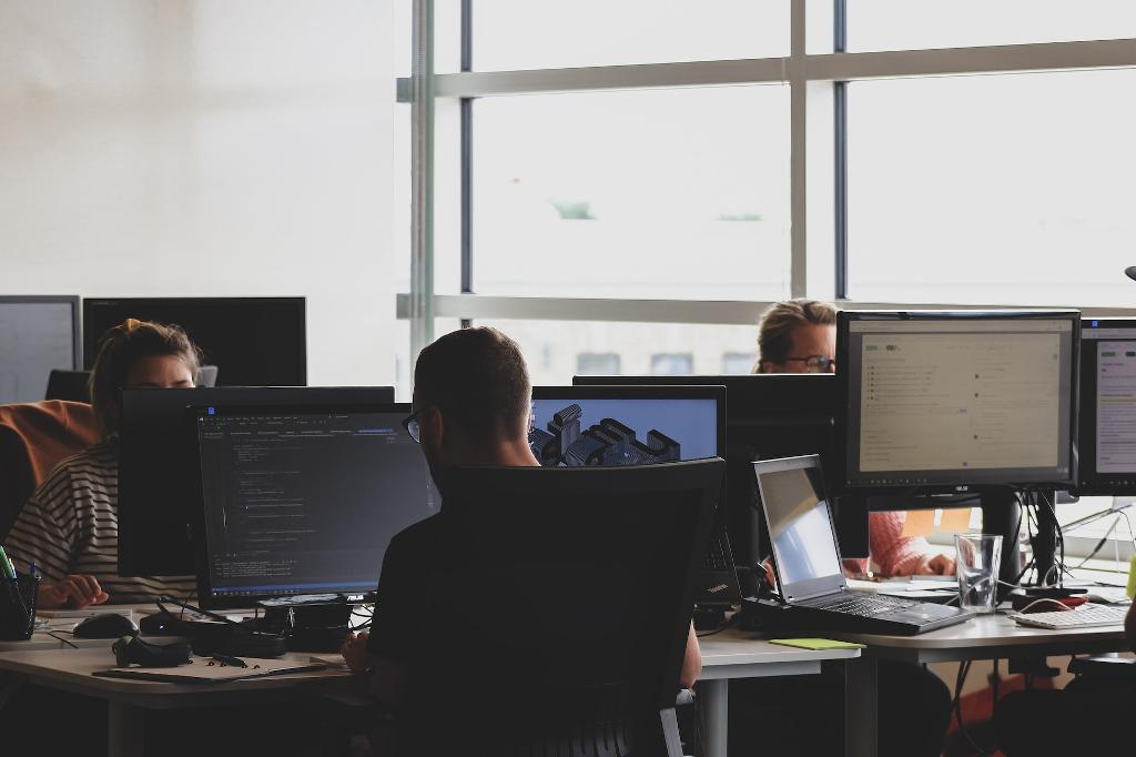 people sitting on chair in front of computer monitor